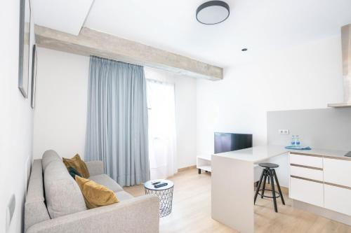 - un salon blanc avec un canapé et un bureau dans l'établissement Sholeo Lodges La Cícer Flats, à Las Palmas de Gran Canaria