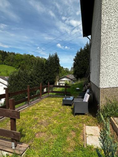 einen Hof mit zwei Bänken und einem Zaun in der Unterkunft Haus am See in Biersdorf