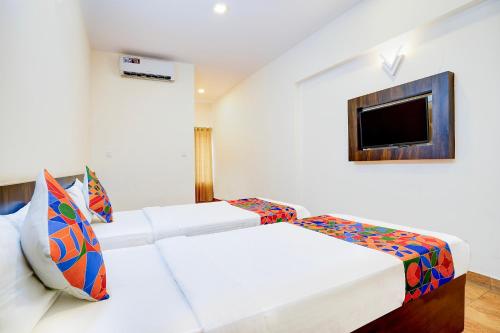 FabHotel GRK Comforts - Jayanagar في بانغالور: غرفة فندقية بسريرين وتلفزيون