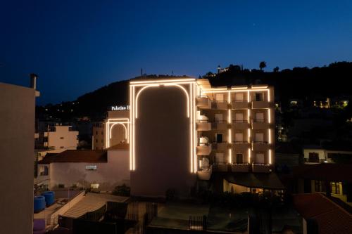 un bâtiment avec des lumières sur son côté la nuit dans l'établissement Palatino Hotel, à Zante