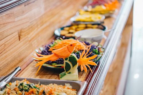 una línea de buffet con platos de comida a la vista en V Hotel Vientiane en Vientián