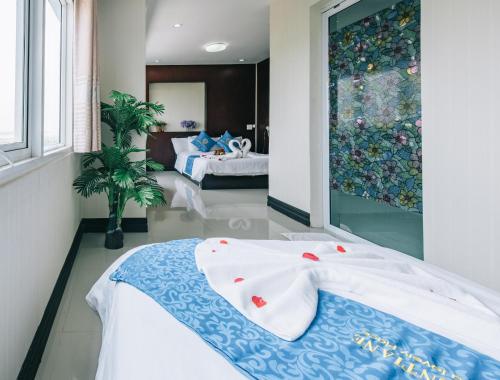 1 dormitorio con 2 camas y ventana grande en V Hotel Vientiane en Vientián