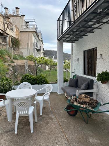 a patio with a couch and a table and chairs at Las Vistas in Bubión