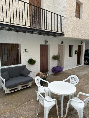 a patio with a couch and a table and chairs at Las Vistas in Bubión