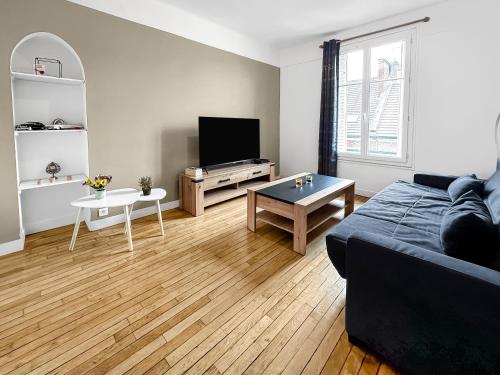 ein Wohnzimmer mit einem Sofa und einem Tisch in der Unterkunft Élégant Pied-à-Terre à Beauvais in Beauvais