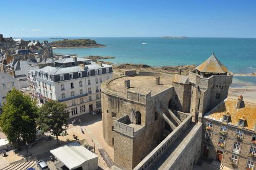 un antiguo castillo con el océano en el fondo en Hôtel France et Chateaubriand, en Saint-Malo