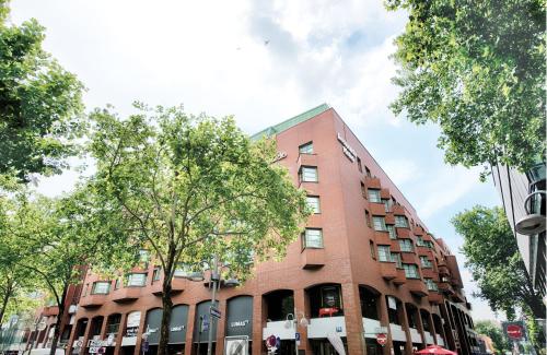 a red brick building on a city street at Leonardo Hotel Mannheim City Center in Mannheim