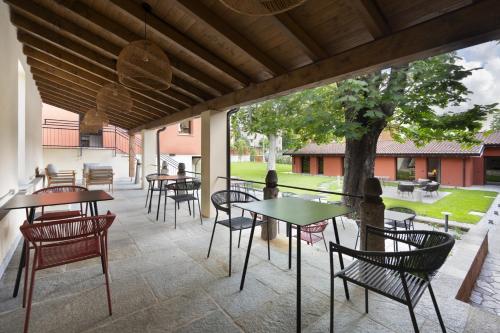 un patio con mesas, sillas y un árbol en Villa Il Platano, en Como