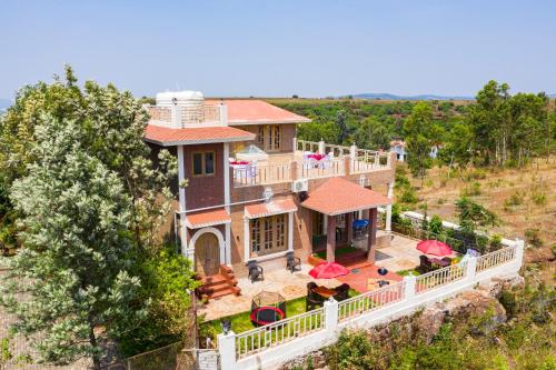 Elle offre une vue sur une grande maison dotée d'un balcon. dans l'établissement TAJ VILLA Mahabaleshwar, à Mahabaleshwar