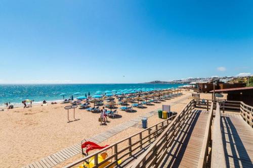 una spiaggia con sedie e ombrelloni e l'oceano di Sea View, Beach 3 minutes ad Albufeira