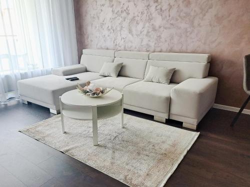 a living room with a white couch and a table at Tabáň Marble apartment (city center & free parking) in Nitra