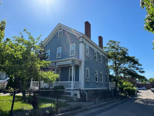 una casa grigia con due camini su una strada di Beautiful Victorian house, Room a Boston