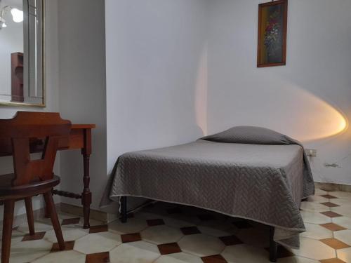 een slaapkamer met een bed, een tafel en een spiegel bij B&B ANXUR in Terracina