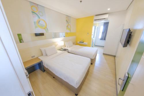 a hotel room with two beds and a television at Go Hotels Lanang - Davao in Davao City