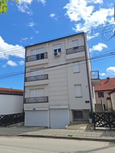 - un immeuble blanc avec deux portes de garage dans l'établissement Apartman Leskovčanka, à Leskovac