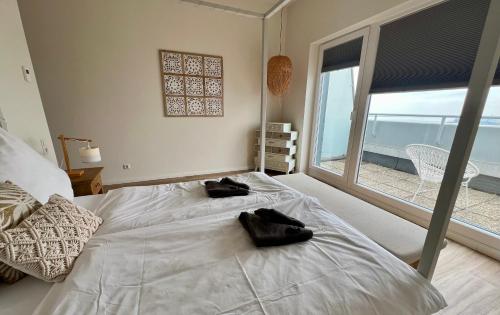 una camera da letto con un grande letto bianco con una grande finestra di COAST HOUSE Sky Suite a Bremerhaven