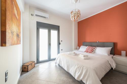 um quarto com uma cama grande e uma parede laranja em Sempre il Mare em Pireu