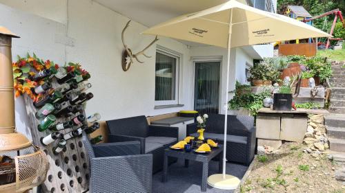 a patio with an umbrella and a table and chairs at 'Tor zum Schwarzwald' Ferienwohnungen in Wildberg