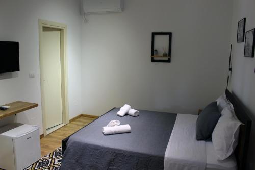 een slaapkamer met een bed met twee handdoeken erop bij Guest House AmaDes in Gjirokastër