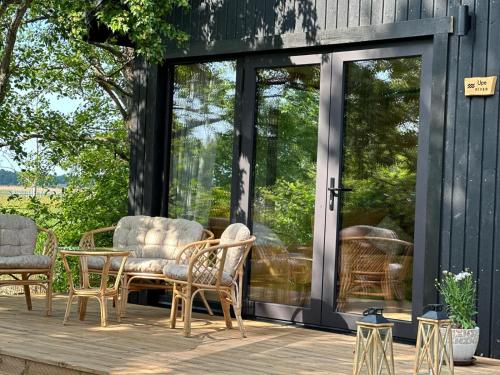 un patio avec des chaises et des tables sur une terrasse en bois dans l'établissement Labieši, à Jurmala