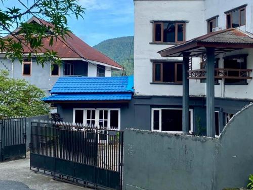 uma casa com um telhado azul e uma cerca em RedDoorz at Hotel Ermashta Jayapura em Jayapura