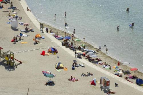 a group of people on a beach near the water at Mobile homes in Zaton Holiday Resort, with large pool area in Zaton