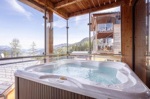 a large bath tub sitting on top of a balcony at Alpenchalets Reiteralm by ALPS RESORTS in Schladming