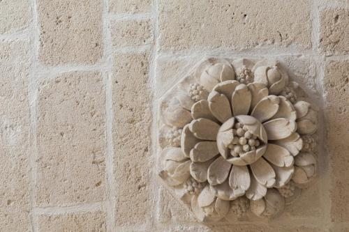 uma flor de pedra na parede de um edifício em Palazzo Zimara Boutique Hotel em Lecce