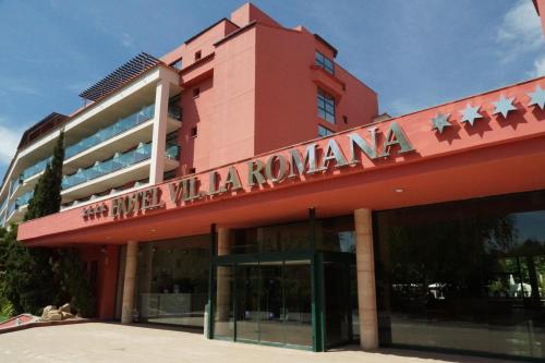 un bâtiment rouge avec un panneau en haut dans l'établissement Ohtels Vil·la Romana, à Salou