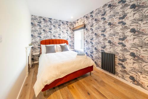 - une chambre avec un lit et un papier peint floral dans l'établissement Boutique Townhouse, à Westport