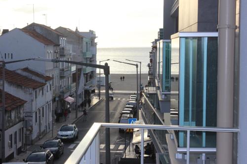 uma vista para uma rua da cidade com uma praia e edifícios em Hospedaria A Primorosa na Nazaré