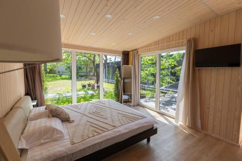 ein Schlafzimmer mit einem Bett und einem großen Fenster in der Unterkunft Baltic Beach Houses & Jomas in Jūrmala