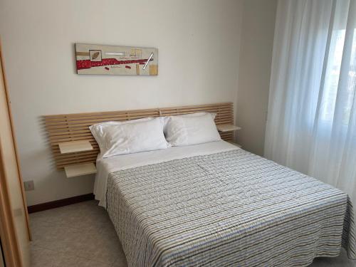 een slaapkamer met een bed met een gestreept dekbed bij Hotel Mayer in Bibione