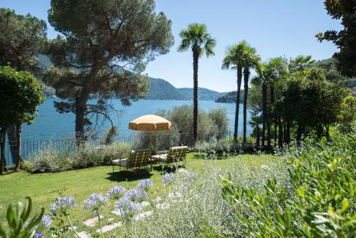 - un jardin avec une table et des chaises et une vue sur l'eau dans l'établissement Passalacqua, à Moltrasio