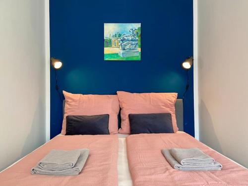 a bedroom with a bed with pink sheets and a blue wall at Apartment am Lutherplatz in Potsdam