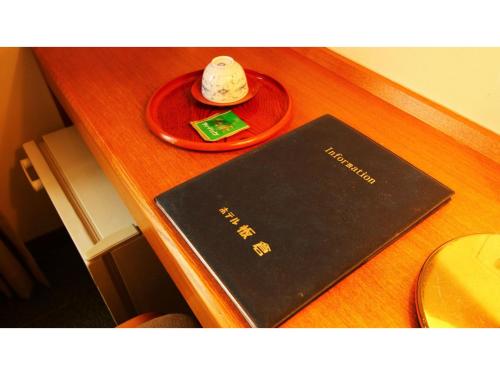 um livro preto sobre uma mesa com uma placa vermelha em Hotel Itakura - Vacation STAY 70112v em Fukushima