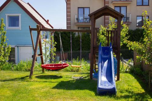 een speeltuin in een tuin met een schommel bij Domki u Marty - Władysławowo in Władysławowo