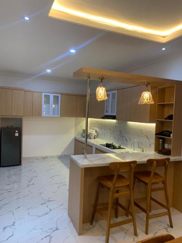 a kitchen with two bar stools and a counter at Wikans Villa in Kuta