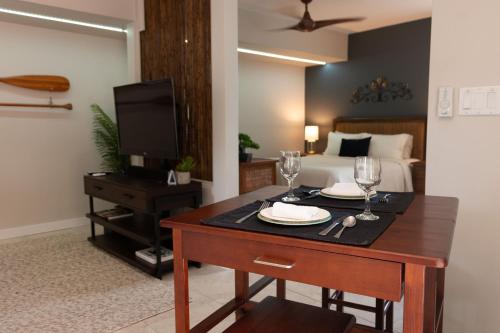 Cette chambre comprend une table avec deux verres et un lit. dans l'établissement Plumeria Cottage, à Kailua-Kona