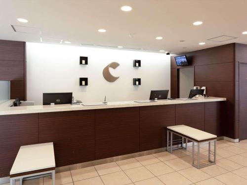 a lobby with a reception desk with two laptops on it at Comfort Hotel Kitakami in Kitakami