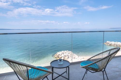 2 sedie e un tavolo sul balcone con vista sull'oceano di Beachfront Apartments Zanic a Podstrana