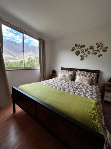 a bedroom with a bed and a large window at Casa Doris in Vicuña