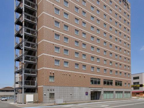 a tall brick building with scaffolding on it at Comfort Hotel Kokura in Kitakyushu