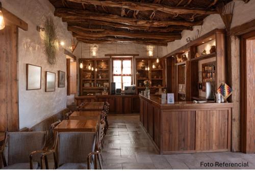 un restaurante con mesas y sillas de madera y un bar en Terrantai Lodge, en San Pedro de Atacama