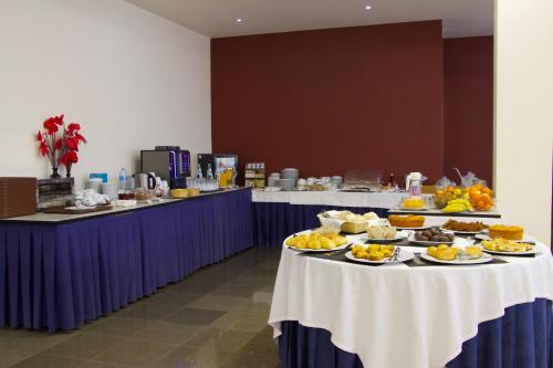 una línea de buffet con platos de comida en las mesas en Hotel Eurosol Alcanena, en Alcanena