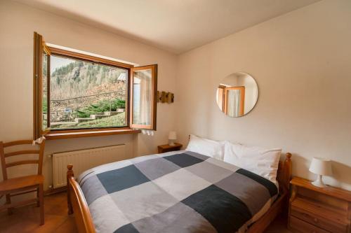 una camera con letto, finestra e specchio di Mountain Bliss Retreat - 20min from Cortina a Borca di Cadore