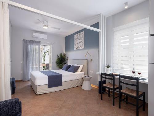 a bedroom with a bed and a desk in it at Elena Seafront Luxury Apartments in Almirida