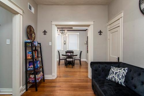 uma sala de estar com um sofá preto e uma mesa em Charming New Orleans-Style Apartment with Gated Courtyard! em Little Rock