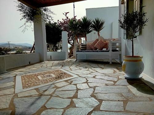 une terrasse en pierre avec une chaise, une table et un sol dans l'établissement Ione Seaside Residence, à Santa Maria