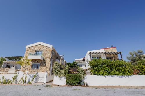 ein Haus mit einem weißen Zaun davor in der Unterkunft Petritis Villas in Nea Iraklitsa